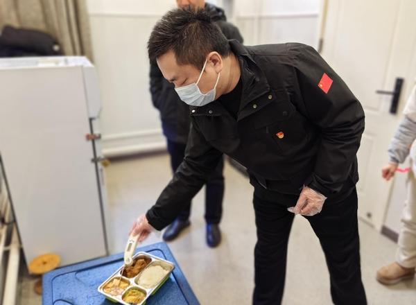 3郑州市第七初级中学东校区党支部书记楚东升，用专用测温计进行餐温测量